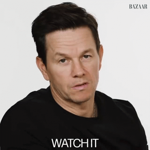 A Man Wearing A Black Shirt Says Watch It In Front Of A White Background GIF