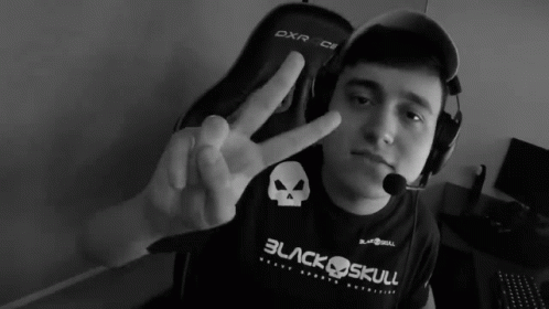A Man Wearing A Black Shirt That Says Black Skull Giving A Peace Sign GIF