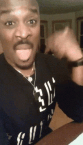 A Man Wearing A Black Shirt That Says ' Gucci ' On It Is Sticking His Tongue Out GIF