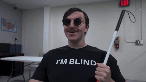 A Man Wearing A Black Shirt That Says I 'M Blind GIF