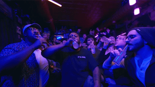 A Man Wearing A Black Shirt That Says It 'S Cool Stands In Front Of A Crowd GIF