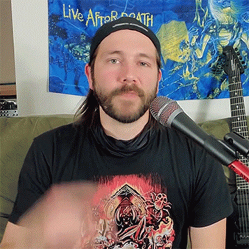 a man wearing a black shirt that says live after death on it