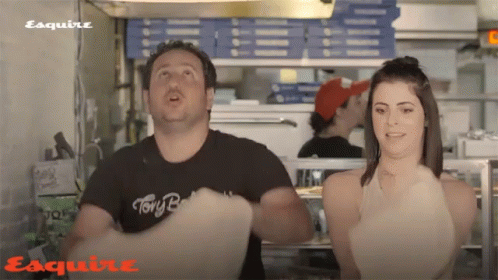 A Man Wearing A Black Shirt That Says " Tony B " Is Standing Next To A Woman GIF