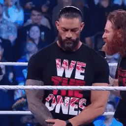 A Man Wearing A Black Shirt That Says We The Ones Is Standing In A Boxing Ring . GIF