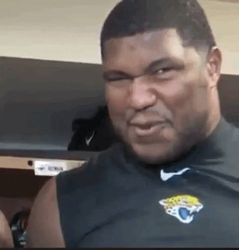 A Man Wearing A Black Shirt With A Jaguars Logo On It Is Making A Funny Face . GIF