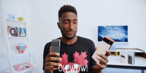 A Man Wearing A Black Shirt With A Maple Leaf On It Is Holding A Cell Phone And A Tablet And Says Oh Wow GIF