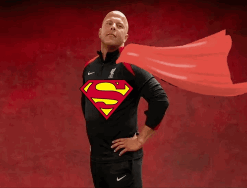 A Man Wearing A Black Shirt With A Superman Logo On The Front GIF