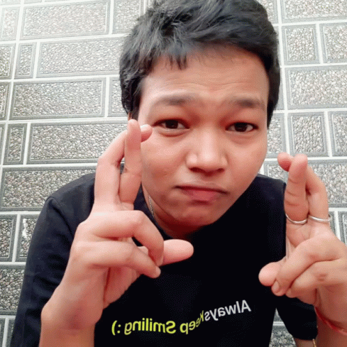 A Man Wearing A Black Shirt With A Yellow Smiley Face On It GIF