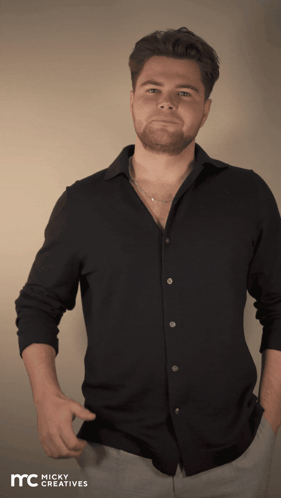 A Man Wearing A Black Shirt With Micky Creatives Written On The Bottom Right GIF