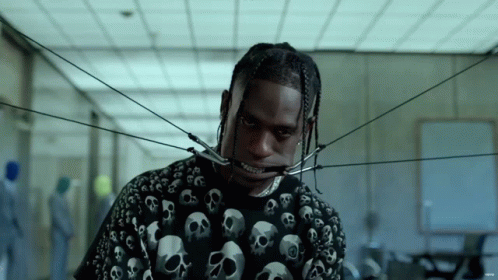 A Man Wearing A Black Shirt With Skulls On It Has A Brace On His Teeth GIF