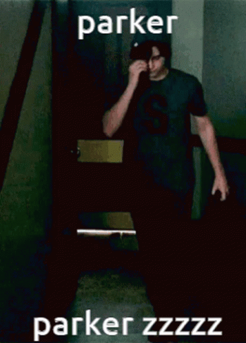 A Man Wearing A Black Shirt With The Letter S On It Wipes His Nose GIF