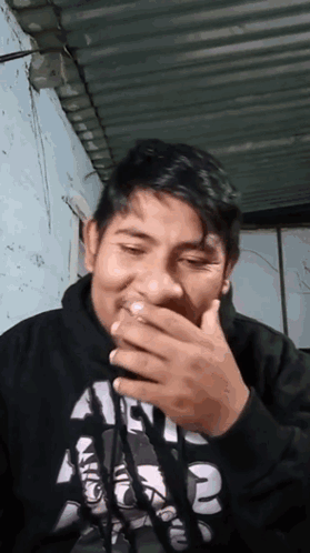 A Man Wearing A Black Shirt With The Number 2 On It Covering His Mouth GIF