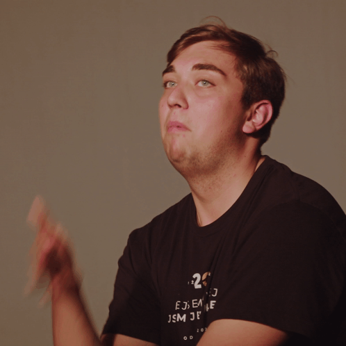 A Man Wearing A Black Shirt With The Number 20 On It Is Making A Funny Face GIF