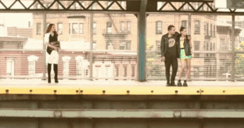 A Man Wearing A Black Shirt With The Number 9 On It Stands Next To Two Women GIF
