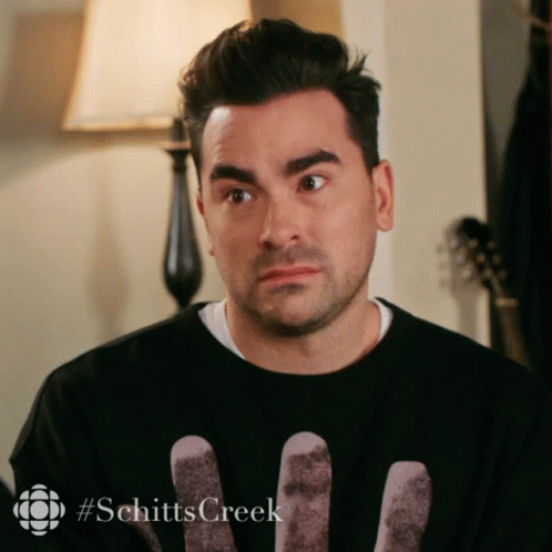 A Man Wearing A Black Shirt With The Word Schitts Creek On The Bottom GIF