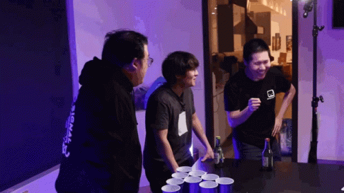 A Man Wearing A Black Shirt With The Word Signal On The Back Is Playing Beer Pong GIF