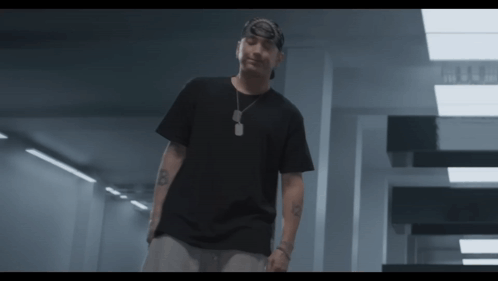 A Man Wearing A Black T-Shirt And A Bandana Has The Letter B On His Arm GIF