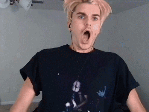 A Man Wearing A Black T-Shirt And Earphones Is Making A Funny Face . GIF