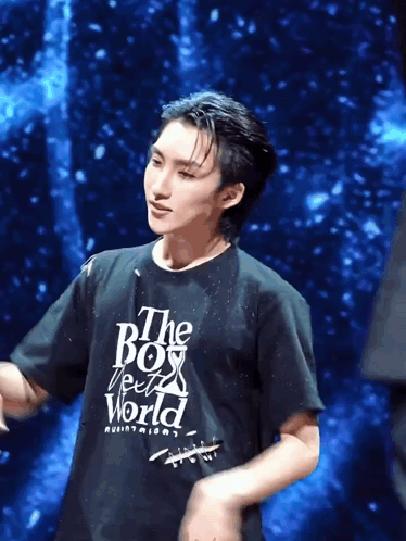 a man wearing a black t-shirt that says " the boy from the world "