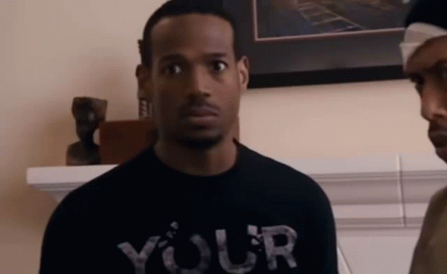 A Man Wearing A Black T-Shirt That Says Your Is Standing Next To Another Man . GIF
