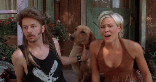 A Man Wearing A Black Tank Top With An Eagle On It Is Standing Next To A Woman And A Dog GIF