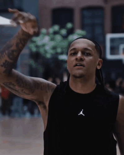 A Man Wearing A Black Tank Top With The Letter J On The Front GIF