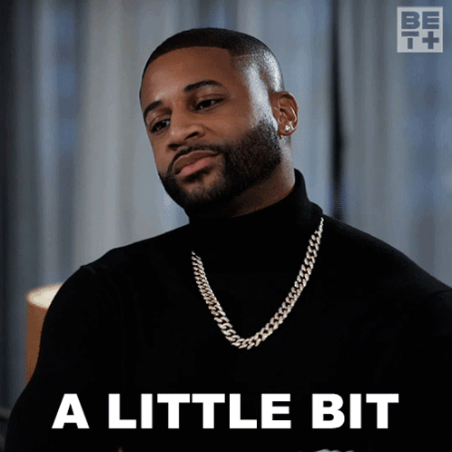 A Man Wearing A Black Turtleneck And A Gold Chain Says A Little Bit GIF