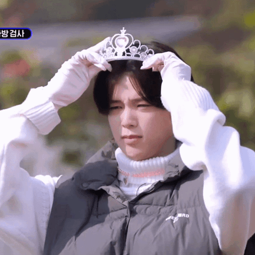 A Man Wearing A Black Vest And White Gloves Is Putting On A Tiara GIF