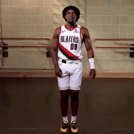A Man Wearing A Blazers Jersey And Shorts Jumps In The Air GIF