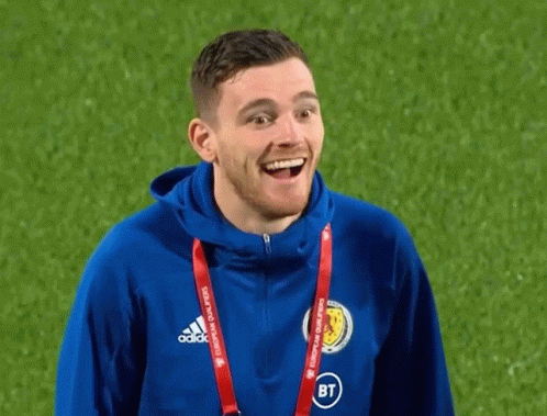 A Man Wearing A Blue Adidas Jacket Is Smiling On A Field GIF