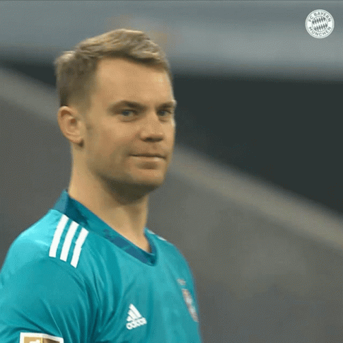 a man wearing a blue adidas shirt looks to the side