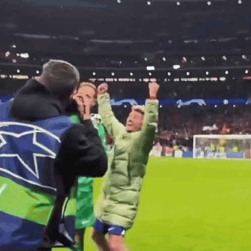 A Man Wearing A Blue And Green Jacket With A Star On It GIF