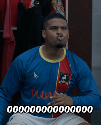 A Man Wearing A Blue And Red Dubai Jersey Making A Funny Face GIF