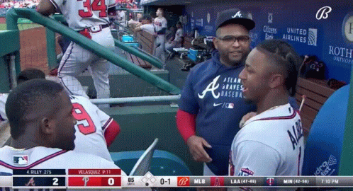 A Man Wearing A Blue Atlanta Braves Baseball Shirt Talks To A Player GIF