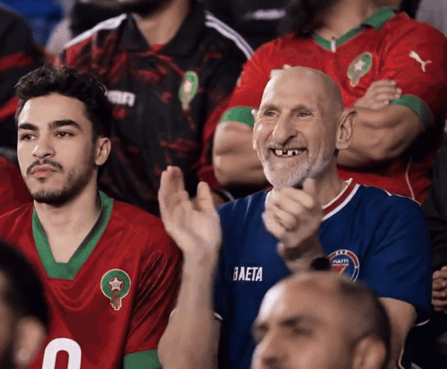 A Man Wearing A Blue Baeta Jersey Applauds In A Crowd GIF