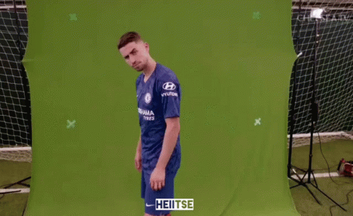 A Man Wearing A Blue Chelsea Jersey Stands In Front Of A Green Screen GIF
