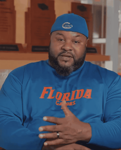 a man wearing a blue florida gators shirt talks