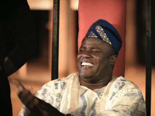 A Man Wearing A Blue Hat And A White Shirt Laughs With His Eyes Closed GIF