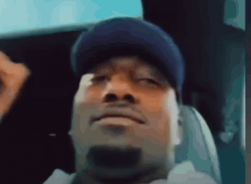 A Man Wearing A Blue Hat Is Sitting In A Chair GIF
