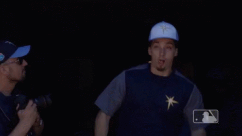 A Man Wearing A Blue Hat With A Star On It Is Pointing GIF