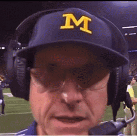 A Man Wearing A Blue Hat With A Yellow Letter M On It GIF