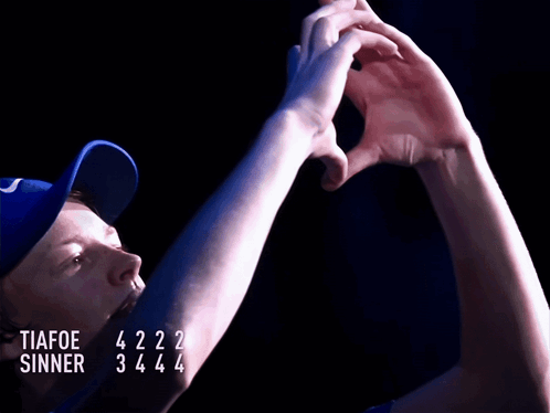 A Man Wearing A Blue Hat With The Words Tiafoe Sinner Written On It GIF