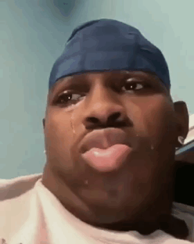 A Man Wearing A Blue Headband Is Crying With A Tear Coming Out Of His Nose . GIF