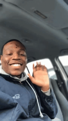 A Man Wearing A Blue Honda Jacket Is Smiling And Waving GIF