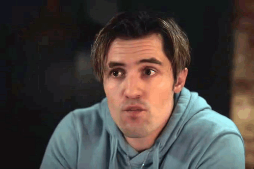 A Man Wearing A Blue Hoodie Is Making A Funny Face . GIF
