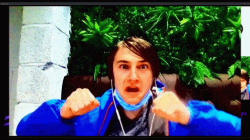 A Man Wearing A Blue Jacket And A Mask Is Making A Funny Face While Talking On A Video Call . GIF