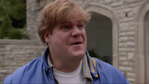 A Man Wearing A Blue Jacket And A White Shirt Is Standing In Front Of A Stone Wall GIF