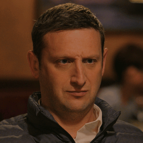 A Man Wearing A Blue Jacket And White Shirt Is Making A Funny Face GIF