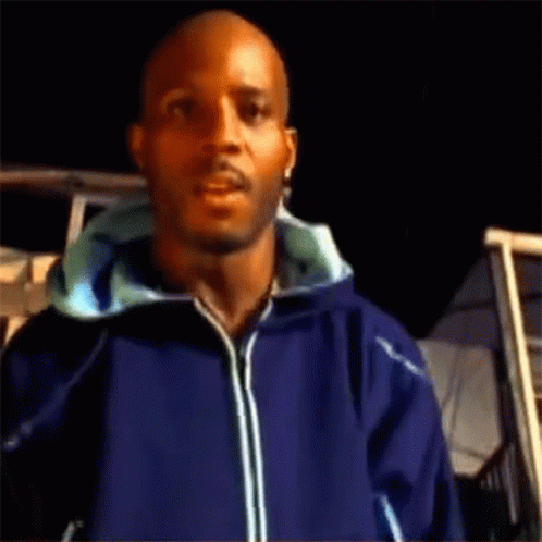 A Man Wearing A Blue Jacket Is Standing In Front Of A Building GIF