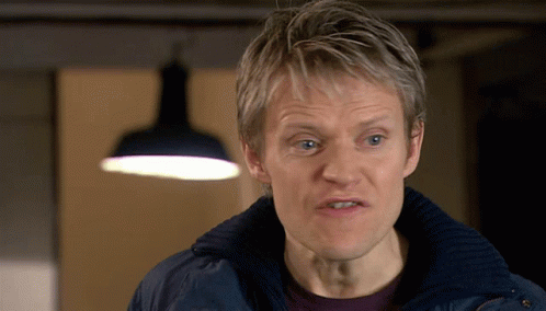 a man wearing a blue jacket looks at the camera